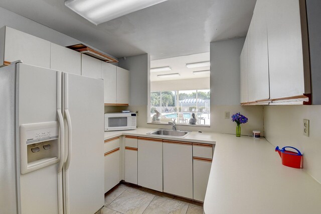 5910 Morningstar Cir Unit 401, Delray Beach, FL 33484 - kitchen with white cabinets, light countertops, white appliances, and a sink