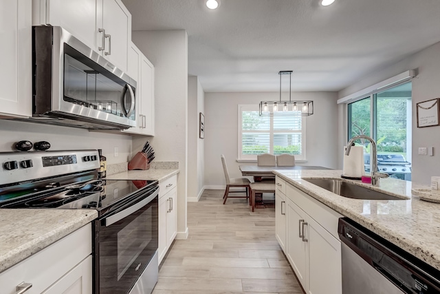 8769 Via, Mar Rosso, Lake Worth, FL 33467 - kitchen with light wood finished floors, white cabinets, a sink, appliances with stainless steel finishes, and hanging light fixtures