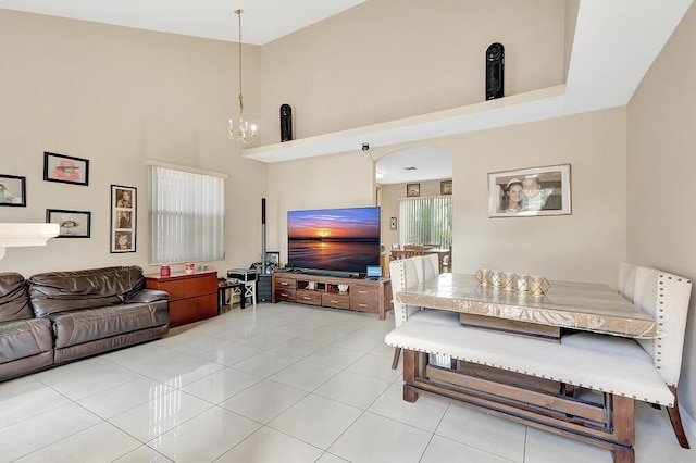 tiled living room with a high ceiling and an inviting chandelier