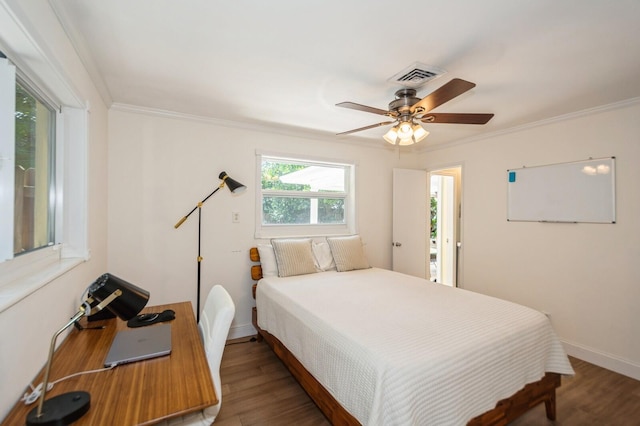 bedroom with baseboards, ornamental molding, wood finished floors, and visible vents