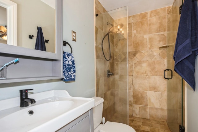 bathroom featuring vanity, toilet, and a stall shower