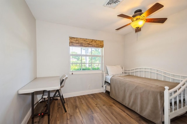 bedroom featuring wood finished floors, visible vents, a ceiling fan, and baseboards