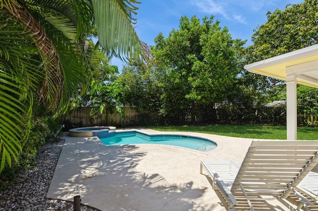 view of pool with a fenced backyard, a patio, and a pool with connected hot tub