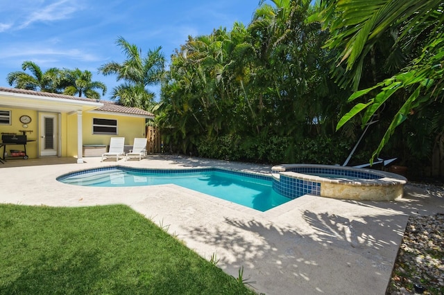 view of swimming pool with area for grilling, a pool with connected hot tub, and a patio
