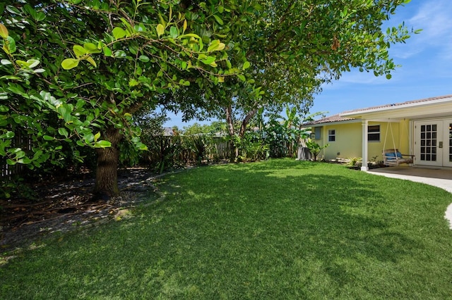 view of yard featuring french doors and fence