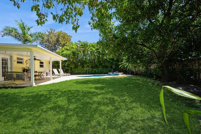 view of yard with ceiling fan, an outdoor pool, and a patio