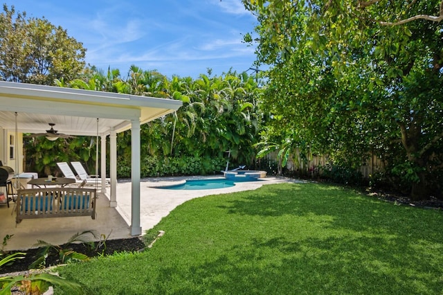 view of yard featuring a patio area, a fenced in pool, a fenced backyard, and ceiling fan