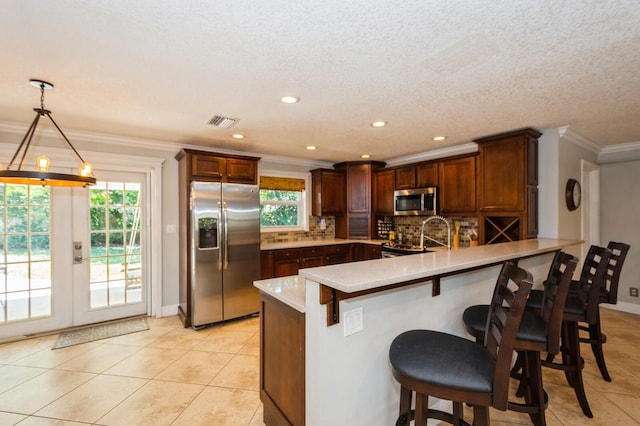 kitchen with a peninsula, visible vents, a wealth of natural light, and stainless steel appliances