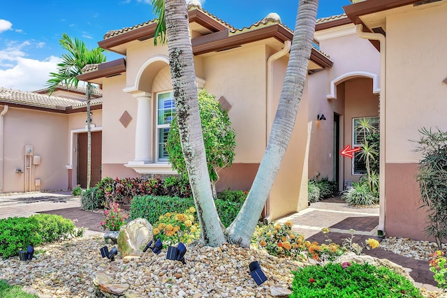 7816 Butera, Delray Beach, FL 33446 - doorway to property featuring a garage, stucco siding, and a tiled roof