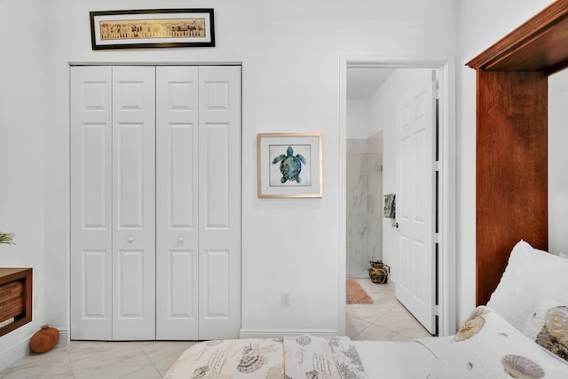 7816 Butera, Delray Beach, FL 33446 - bedroom featuring light marble finish floors, a closet, connected bathroom, and baseboards
