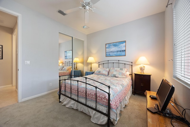 bedroom with a closet, light carpet, ceiling fan, baseboards, and visible vents