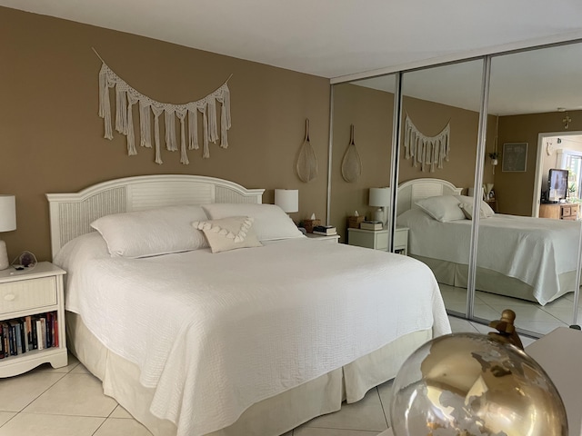 bedroom with visible vents, light tile patterned floors, multiple windows, and a closet