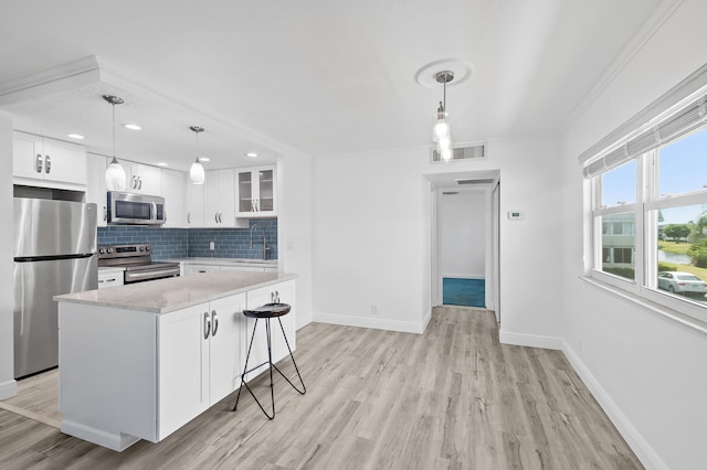 574 Monaco L, Delray Beach, FL 33446 - kitchen with visible vents, light wood-type flooring, tasteful backsplash, a sink, and appliances with stainless steel finishes