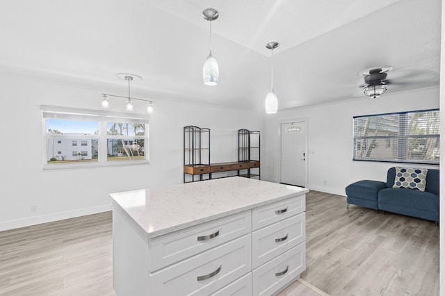 574 Monaco L, Delray Beach, FL 33446 - kitchen featuring plenty of natural light, light wood-type flooring, white cabinets, and pendant lighting