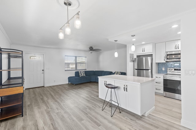 574 Monaco L, Delray Beach, FL 33446 - kitchen with appliances with stainless steel finishes, open floor plan, a ceiling fan, white cabinets, and a breakfast bar