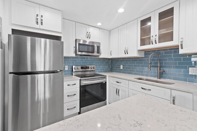 574 Monaco L, Delray Beach, FL 33446 - kitchen featuring stainless steel appliances, glass insert cabinets, white cabinetry, light stone countertops, and tasteful backsplash