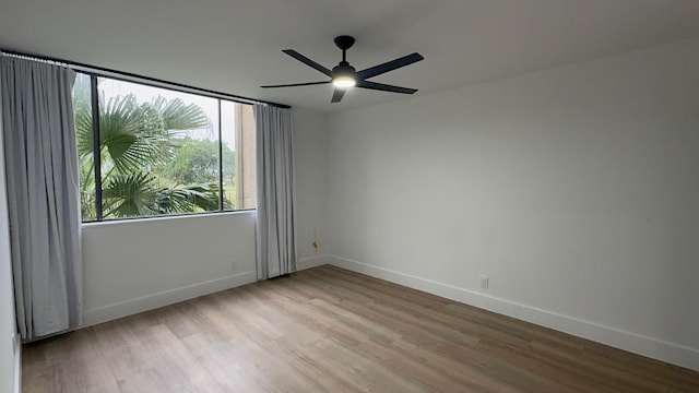 spare room with baseboards, a ceiling fan, and wood finished floors