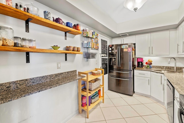 kitchen with light tile patterned floors, stainless steel appliances, open shelves, a sink, and white cabinetry