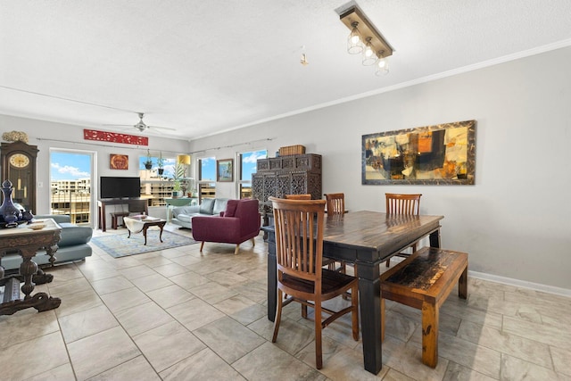 dining area with baseboards, ornamental molding, and a ceiling fan