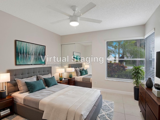 bedroom featuring a textured ceiling, a ceiling fan, baseboards, and light tile patterned floors