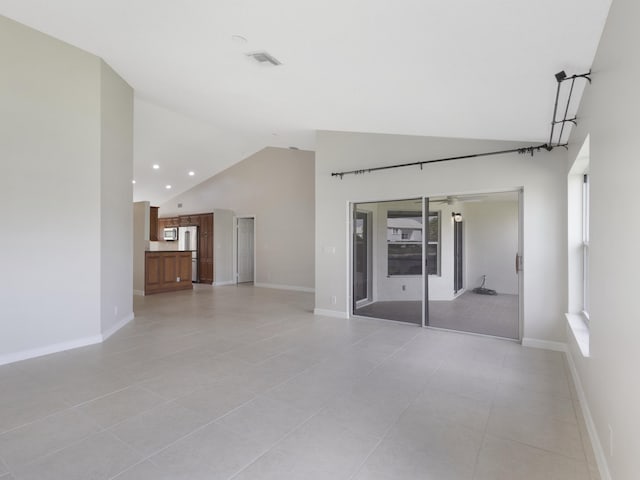 interior space featuring high vaulted ceiling, light tile patterned floors, baseboards, visible vents, and recessed lighting