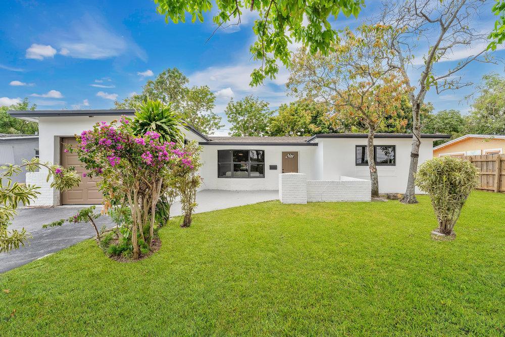 4450 NW 25th St, Lauderhill, FL 33313 - single story home with an attached garage, fence, a front yard, and stucco siding