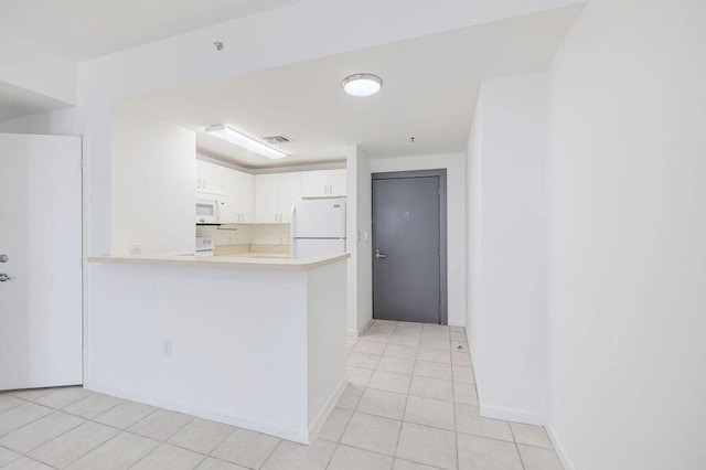 kitchen featuring white cabinets, light countertops, white appliances, light tile patterned flooring, and baseboards