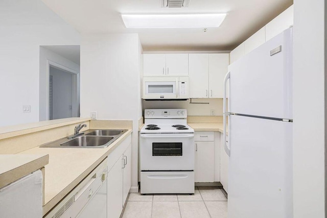 kitchen with a sink, white cabinetry, white appliances, light countertops, and light tile patterned floors
