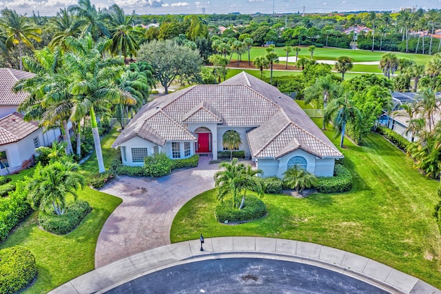 view of front of property with stucco siding, a tile roof, decorative driveway, and a front lawn