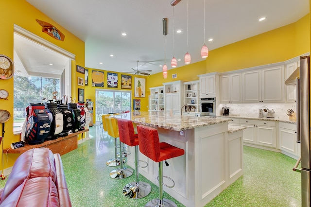 kitchen featuring recessed lighting, stainless steel appliances, white cabinetry, decorative backsplash, and ceiling fan