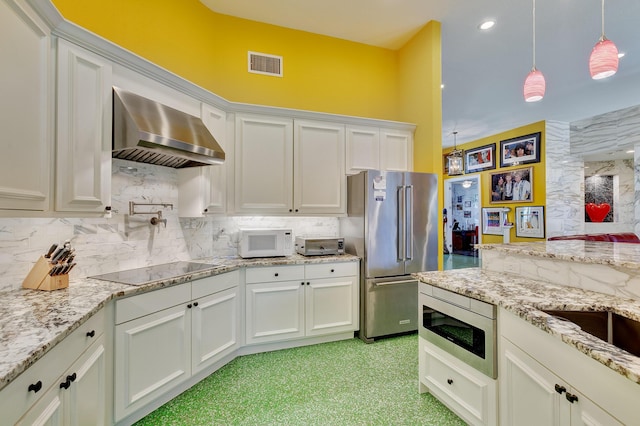 kitchen featuring backsplash, wall chimney exhaust hood, stainless steel appliances, and visible vents