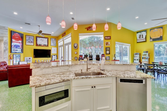 kitchen featuring lofted ceiling, open floor plan, a sink, and appliances with stainless steel finishes