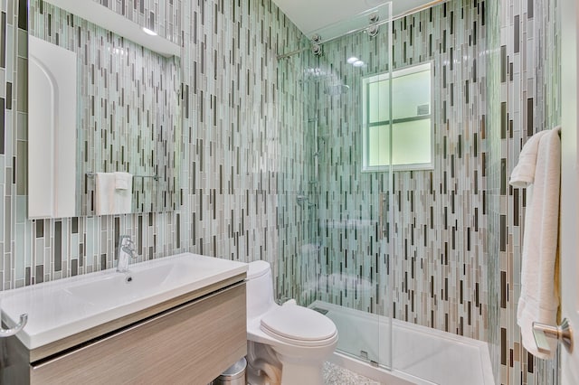 bathroom with a stall shower, decorative backsplash, vanity, tile walls, and toilet