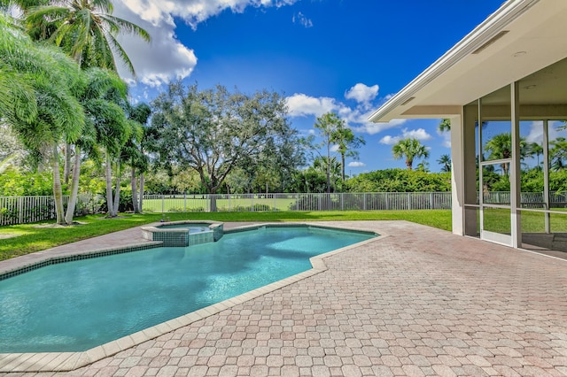 view of swimming pool featuring a yard, a pool with connected hot tub, a fenced backyard, and a patio