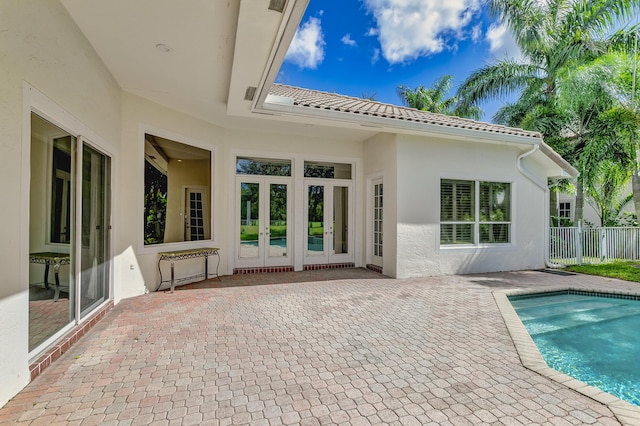 back of house featuring a patio area, french doors, fence, a fenced in pool, and stucco siding
