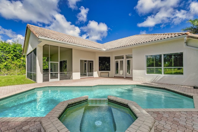 rear view of house with a tile roof, french doors, stucco siding, a sunroom, and a pool with connected hot tub