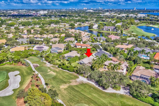 birds eye view of property with view of golf course, a water view, and a residential view