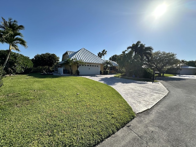 view of front of house featuring a garage, a front lawn, stucco siding, and driveway
