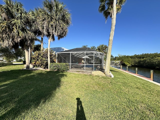 view of yard featuring a water view and glass enclosure