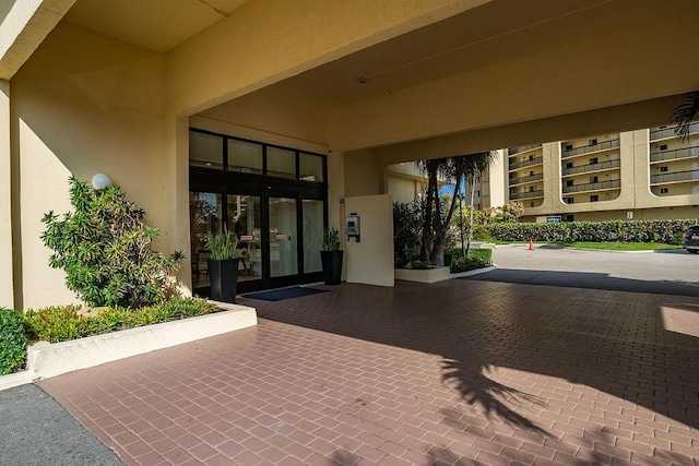 doorway to property featuring french doors and stucco siding