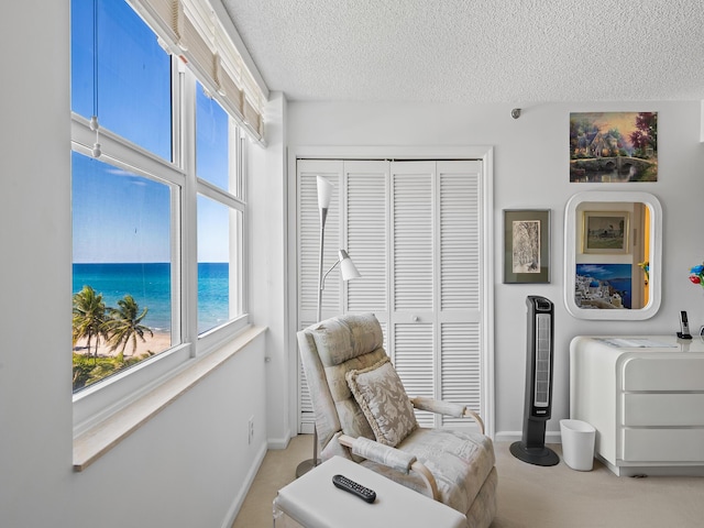 3407 S Ocean Blvd Unit 7A, Highland Beach, FL 33487 - living area with a textured ceiling, baseboards, and a water view