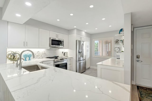 5749 Gemstone Ct Unit 404, Boynton Beach, FL 33437 - kitchen with stainless steel appliances, a peninsula, a sink, recessed lighting, and light stone counters