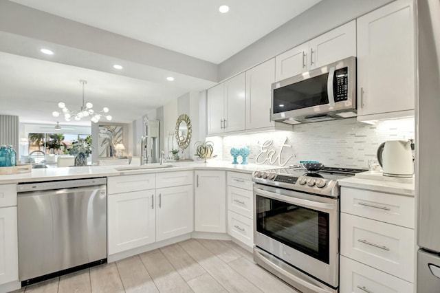 5749 Gemstone Ct Unit 404, Boynton Beach, FL 33437 - kitchen featuring stainless steel appliances, a sink, backsplash, a notable chandelier, and light countertops