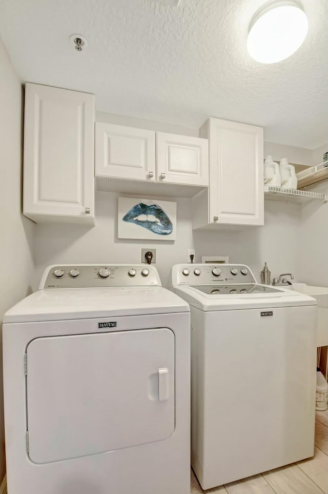 5749 Gemstone Ct Unit 404, Boynton Beach, FL 33437 - laundry room featuring separate washer and dryer, cabinet space, a textured ceiling, and light tile patterned floors