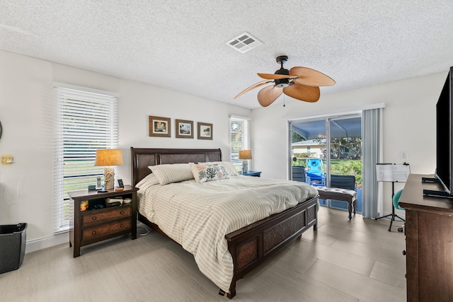 13756 Via Flora Unit A, Delray Beach, FL 33484 - bedroom with a textured ceiling, visible vents, a ceiling fan, and access to exterior