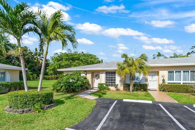 13756 Via Flora Unit A, Delray Beach, FL 33484 - view of front of home with uncovered parking, a front yard, and stucco siding
