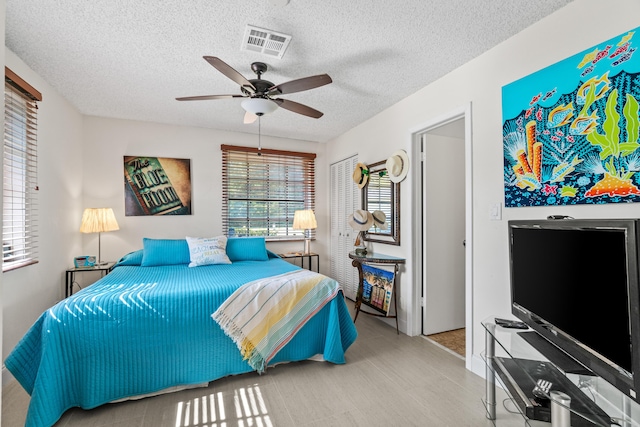 13756 Via Flora Unit A, Delray Beach, FL 33484 - bedroom featuring a textured ceiling, visible vents, wood finished floors, a closet, and ceiling fan