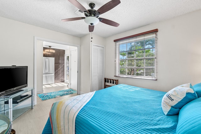 13756 Via Flora Unit A, Delray Beach, FL 33484 - bedroom featuring stainless steel refrigerator, a closet, a textured ceiling, ceiling fan, and ensuite bathroom
