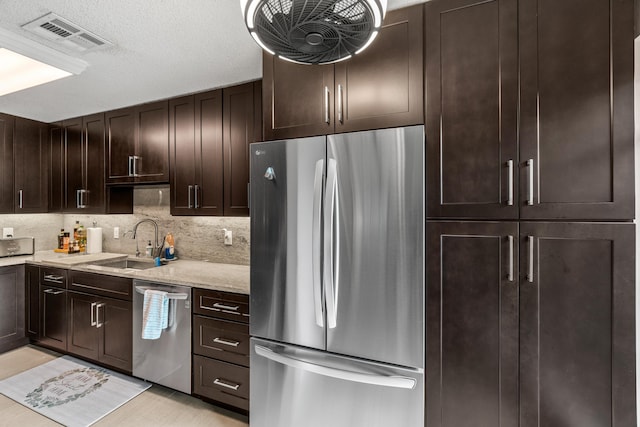 13756 Via Flora Unit A, Delray Beach, FL 33484 - kitchen with stainless steel appliances, backsplash, visible vents, a sink, and dark brown cabinetry