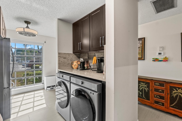13756 Via Flora Unit A, Delray Beach, FL 33484 - laundry area featuring a textured ceiling, visible vents, laundry area, and washer and clothes dryer